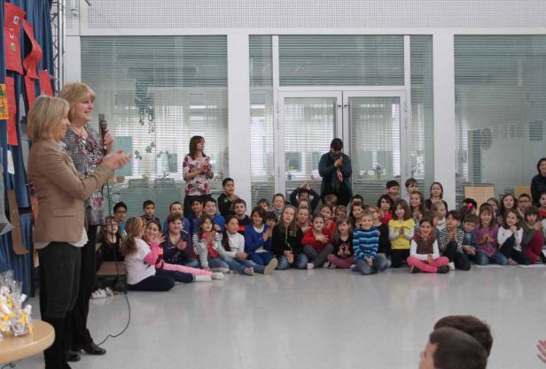 Zwei Frauen sprechen vor einer Gruppe von Schulkindern.