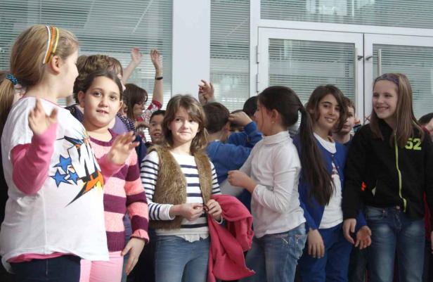 Eine Gruppe von Schulkindern steht zusammen und unterhält sich.