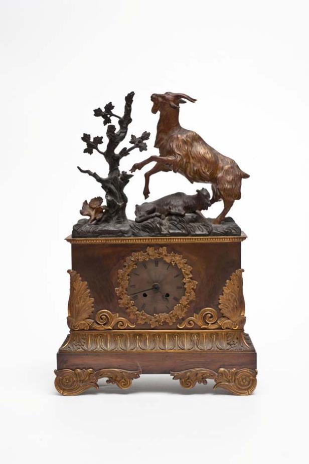 Eine antike Uhr mit einer Skulptur einer Ziege und eines Bären auf der Oberseite.