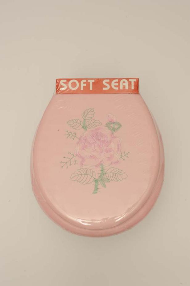 Ein neuer, rosafarbener Toilettensitz mit Rosenmuster und der Aufschrift „Soft Seat“.