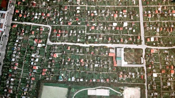 Luftaufnahme einer Kleingartenanlage mit kleinen Häusern und grünen Gärten.