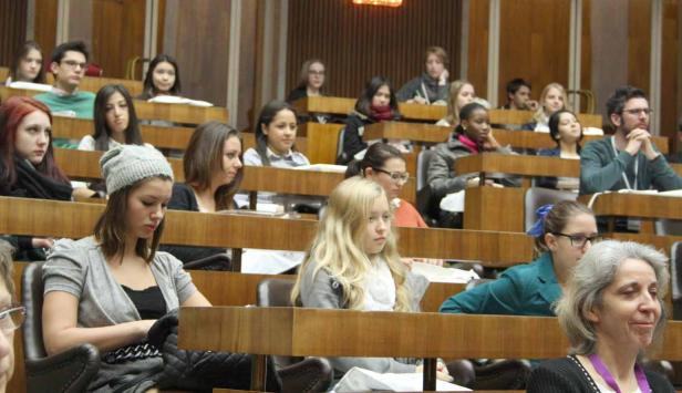 Zahlreiche Studenten sitzen in einem Hörsaal während einer Vorlesung.