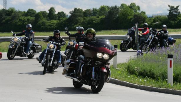 Eine Gruppe von Motorradfahrern fährt auf einer Straße entlang.