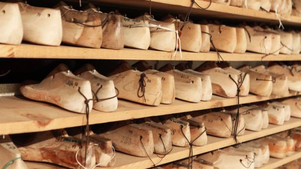 Regale gefüllt mit hölzernen Schuhleisten in verschiedenen Größen.