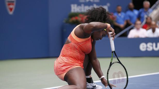 Serena Williams kniet während eines Tennisspiels auf dem Platz.
