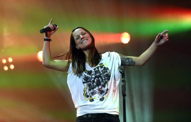 Sängerin Jennifer Weist von der Band Jennifer Rostock tritt auf einer Bühne auf.
