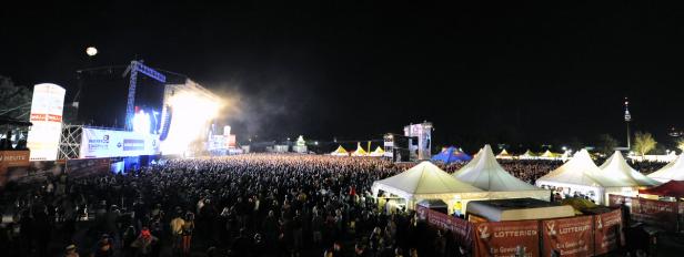 Blick auf eine große Menschenmenge vor einer Bühne auf dem Donauinselfest bei Nacht.