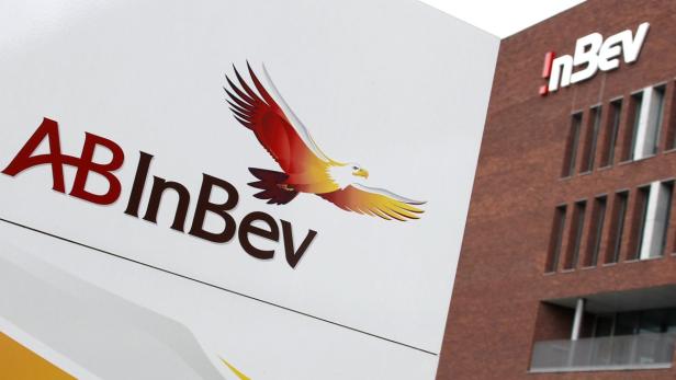 Das Logo von AB InBev mit einem stilisierten Adler vor einem Bürogebäude.