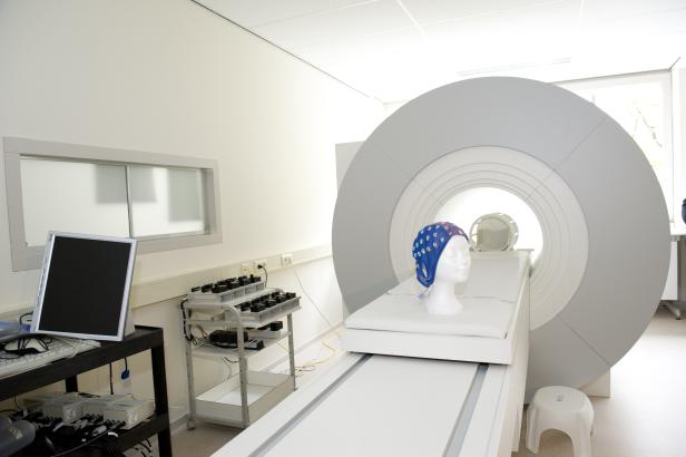 Ein MRT-Gerät mit einer Schaufensterpuppe, die eine EEG-Haube trägt.
