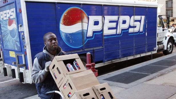 Ein Mann transportiert Kisten mit Pepsi-Dosen vor einem Pepsi-Lieferwagen.