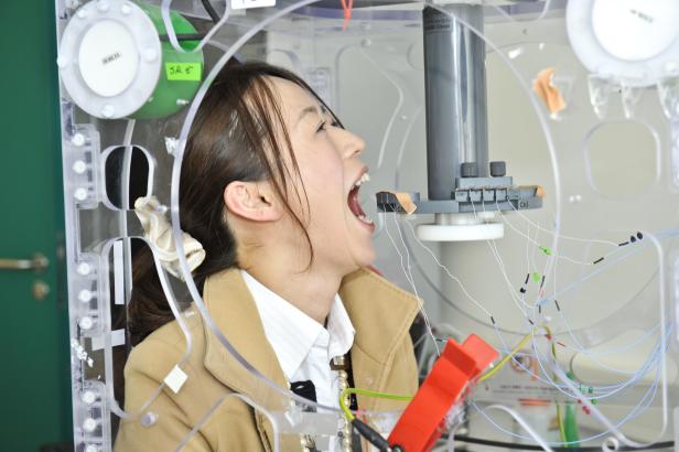 Eine Frau unterzieht sich einer medizinischen Untersuchung mit Elektroden im Mund.