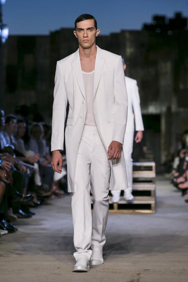 Ein Mann in einem weißen Anzug auf einem Laufsteg.