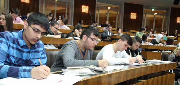 Studenten sitzen in einem Hörsaal und schreiben Klausur.