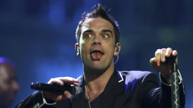 Robbie Williams macht während eines Auftritts Grimassen.