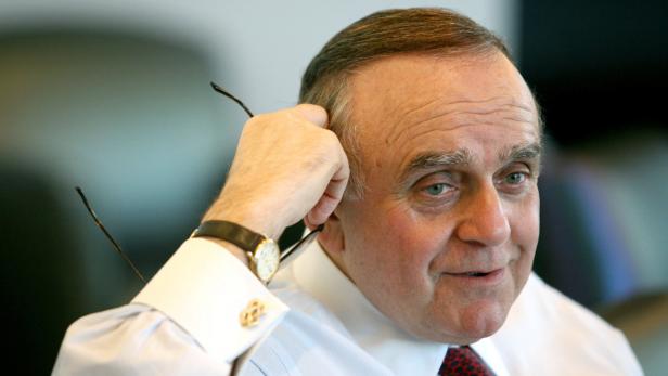 Ein Mann mittleren Alters hält seine Brille am Kopf.