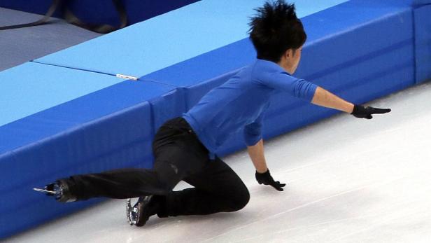 Ein Eiskunstläufer stürzt auf dem Eis.