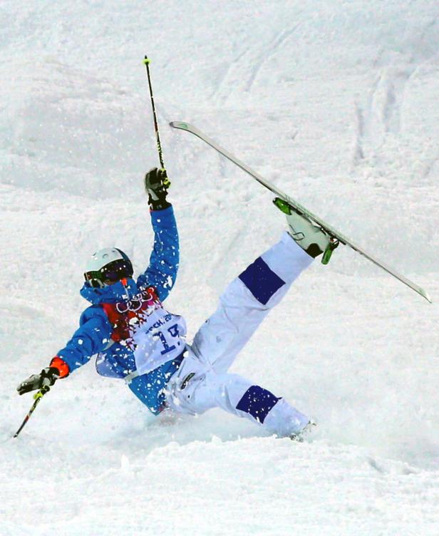 Ein Skifahrer stürzt während eines Wettbewerbs im Schnee.