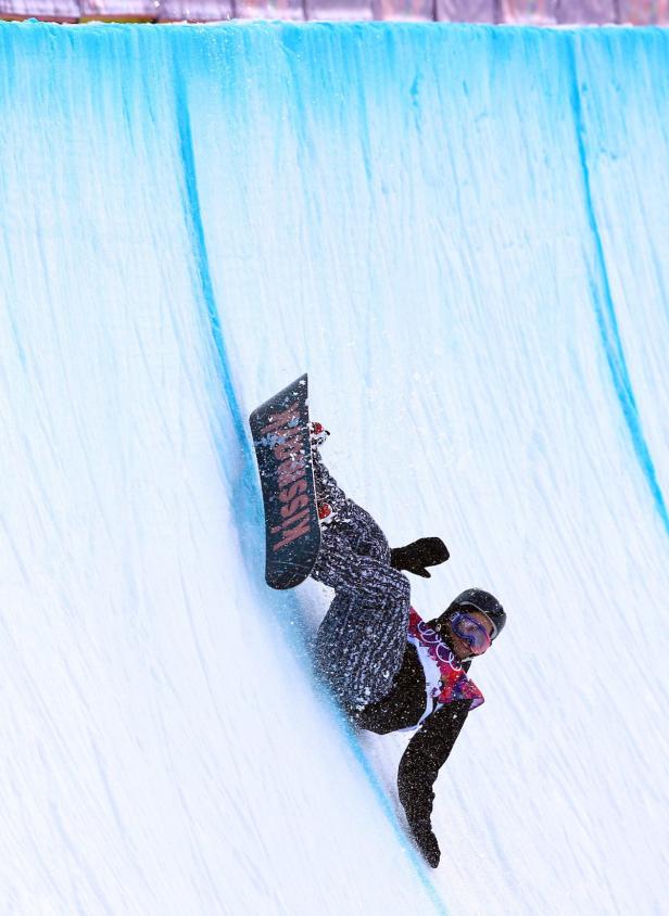 Ein Snowboarder fährt eine Halfpipe hinunter.