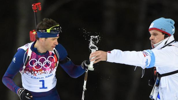 Ein Biathlet wird während eines Wettkampfs mit Flüssigkeit versorgt.