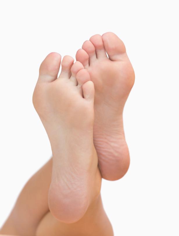 Zwei nackte Füße sind übereinander gelegt.