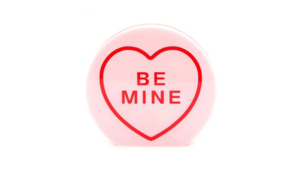 Ein rosa Herz mit der Aufschrift „Be Mine“ auf weißem Hintergrund.