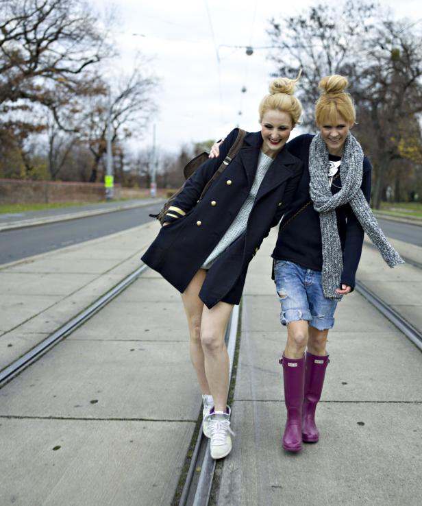 Zwei blonde Frauen gehen auf einem Bahngleis entlang.