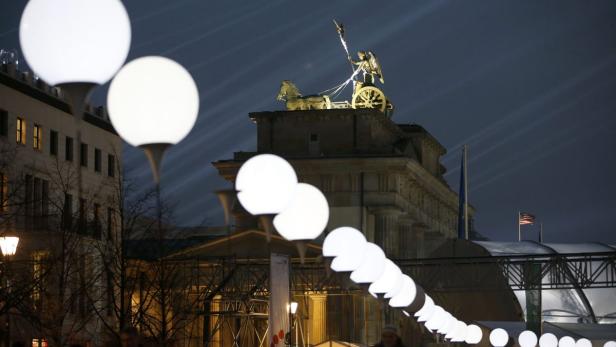 Das Brandenburger Tor in Berlin bei Nacht, geschmückt mit leuchtenden Kugeln.