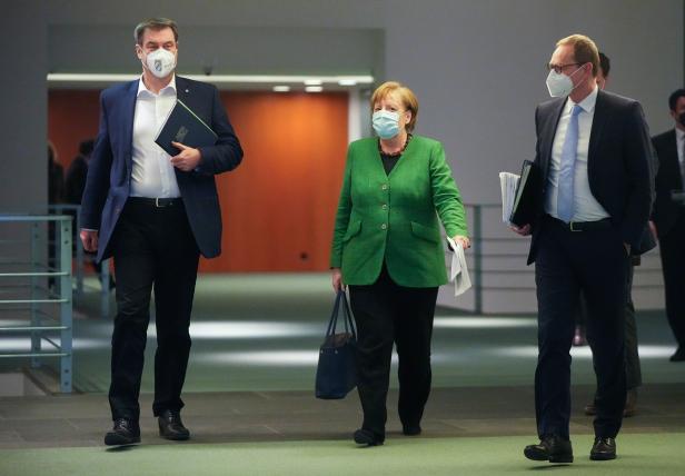 Germany's Merkel walks with Bavarian State Premier Soeder and Berlin Mayor Mueller after discussing COVID-19 lockdown extension with state premiers
