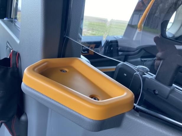 Ein gelber Aschenbecher ist an der Tür eines Taxis befestigt.