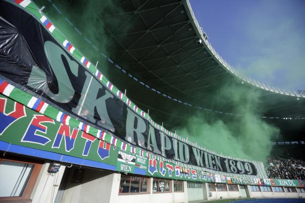 Ein Banner von SK Rapid Wien im Stadion mit grünem Rauch.
