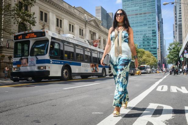 Eine Frau geht in New York an einem Bus der Linie M4 vorbei.
