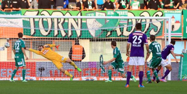 Ein Fußballtorwart hechtet nach dem Ball während eines Fußballspiels.