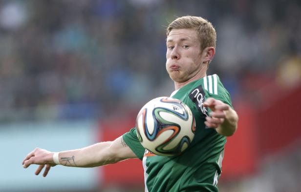 Ein Fußballspieler nimmt einen Ball mit der Brust an.