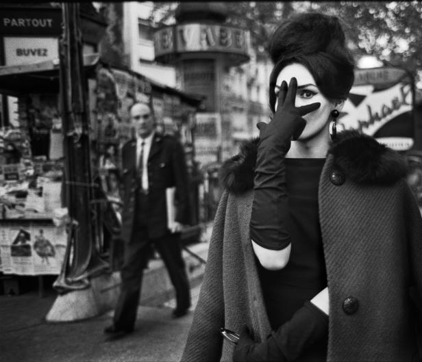 Eine stilvolle Frau in Paris verdeckt ein Auge mit einem Handschuh.