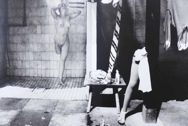 Eine Frau mit einer Beinprothese duscht in einem Badezimmer.