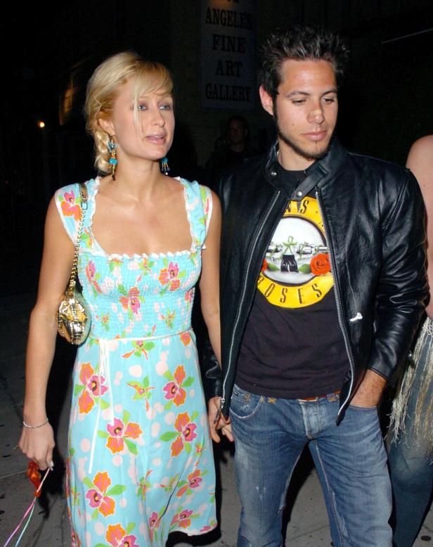 Paris Hilton und ein Mann mit Guns N' Roses T-Shirt gehen Hand in Hand.