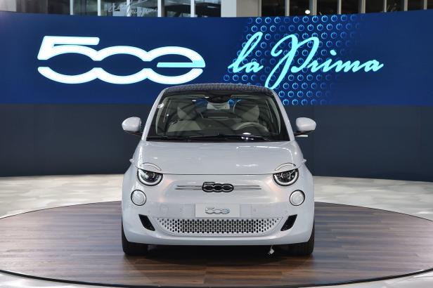 Ein weißer Fiat 500 „la Prima“ steht auf einer Drehscheibe.