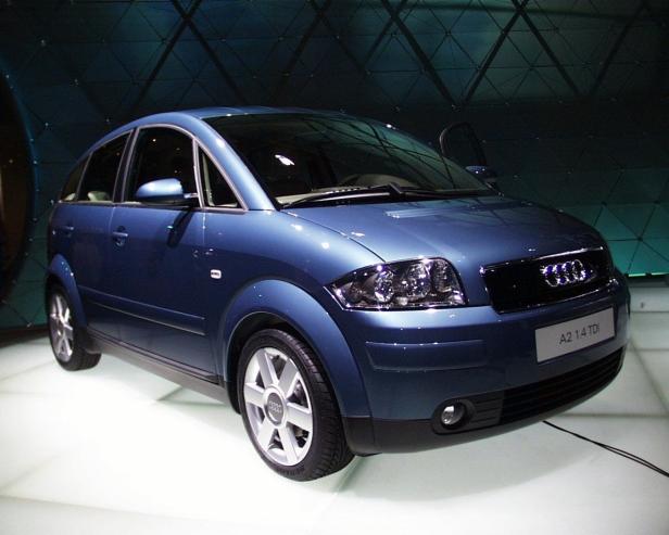 Ein blauer Audi A2 1.4 TDI steht auf einer hellen Ausstellungsfläche.