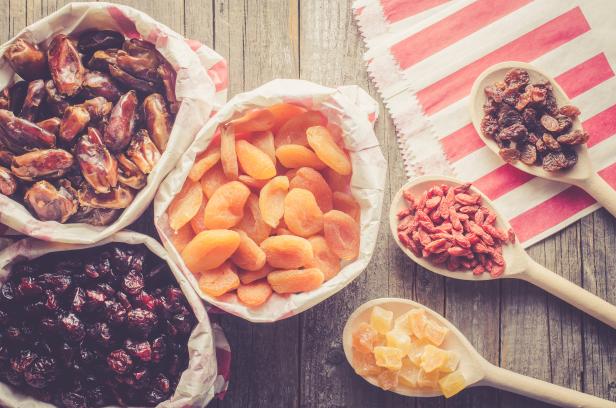 Dried fruits in paper bag on wooden table