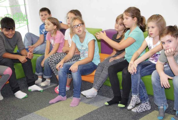Eine Gruppe von Kindern sitzt auf einer bunten Couch.
