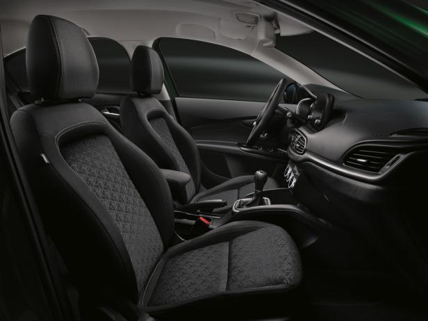 Innenraum eines Autos mit schwarzen Stoffsitzen und einem Schaltknüppel.