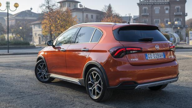 Ein orangefarbener Fiat Tipo Cross steht auf einer Straße.