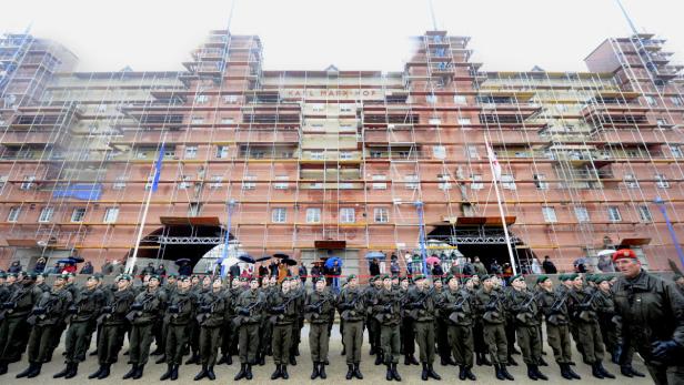 Soldaten stehen vor dem Karl-Marx-Hof, der von einem Gerüst umgeben ist.