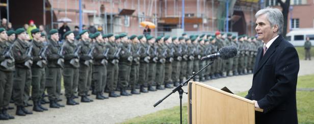 Ein Mann spricht vor einer Reihe von Soldaten in Uniformen.