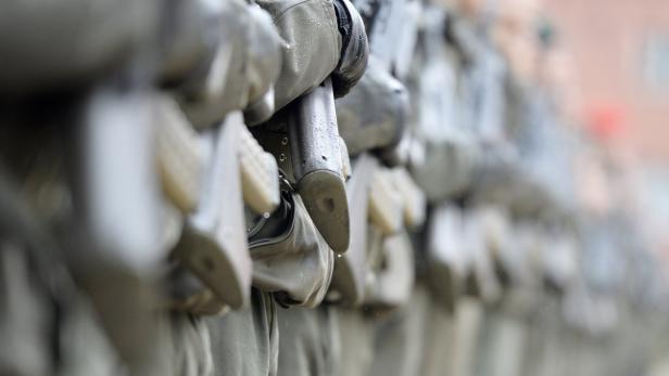 Eine Reihe von Soldaten in Uniform mit Gewehren im Anschlag.