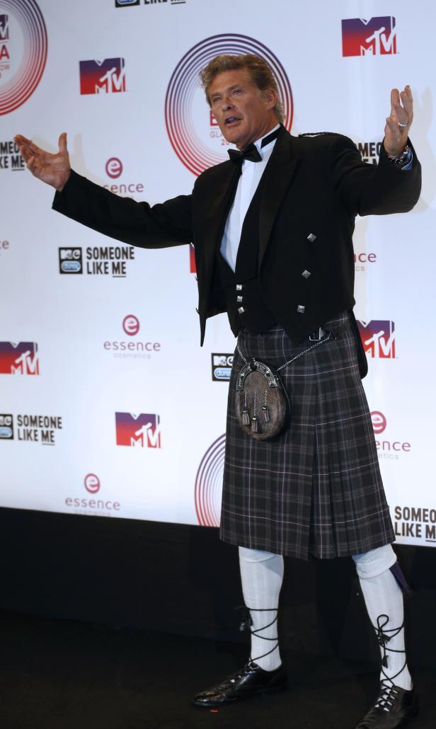 David Hasselhoff im Kilt posiert vor einer MTV-Wand.