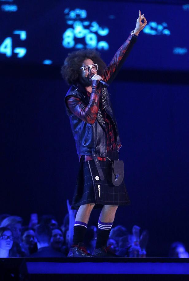 Redfoo tritt in einem Schottenrock und einer Lederjacke auf einer Bühne auf.
