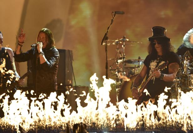 Slash und Myles Kennedy treten mit brennenden Flammen im Vordergrund auf einer Bühne auf.