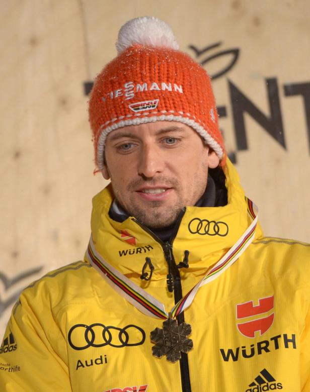 Ein Mann mit einer Medaille und einer orangefarbenen Mütze mit der Aufschrift „Viessmann“.