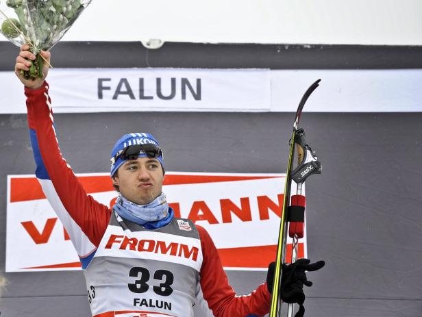 Ein Skilangläufer mit Blumenstrauß auf dem Siegerpodest in Falun.